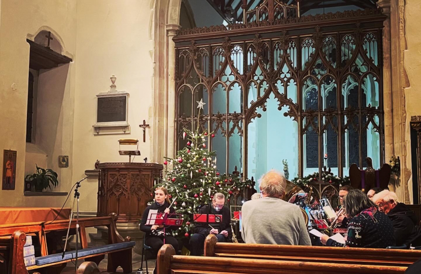 Christmas tree inside church set in front of rows of pews 